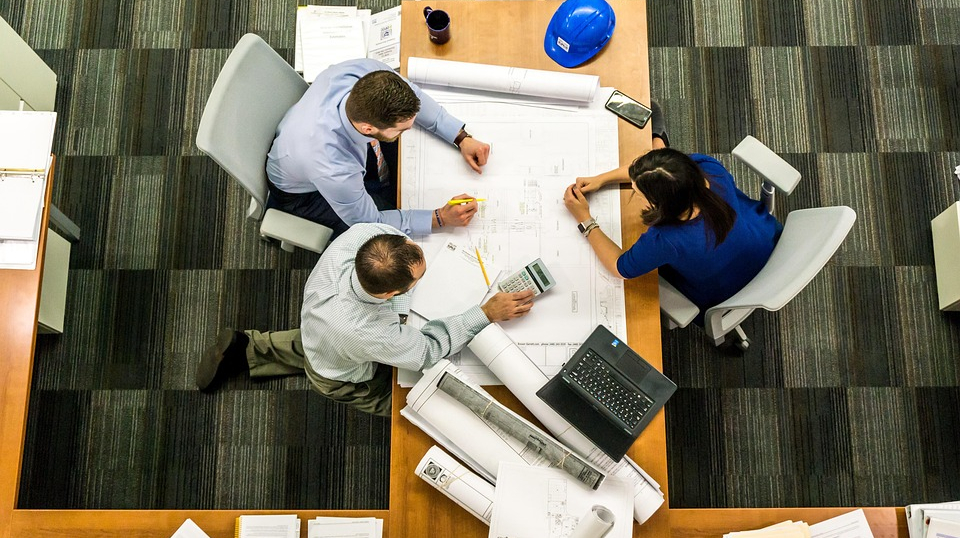 Ein Firmenteam arbeitet gemeinsam auf Papier an einem Projekt Ein Firmenteam arbeitet gemeinsam auf Papier an einem Projekt