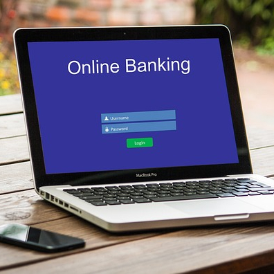 Ein Laptop steht aufgeklappt auf einem Tisch und zeigt die Startmaske des Onlinebanking Ein Laptop steht aufgeklappt auf einem Tisch und zeigt die Startmaske des Onlinebanking