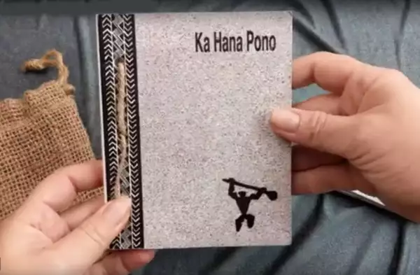 Das Ka Hana Pono Buch in den Händen einer Frau, die dieses Präsentiert. Das Ka Hana Pono Buch in den Händen einer Frau, die dieses Präsentiert.